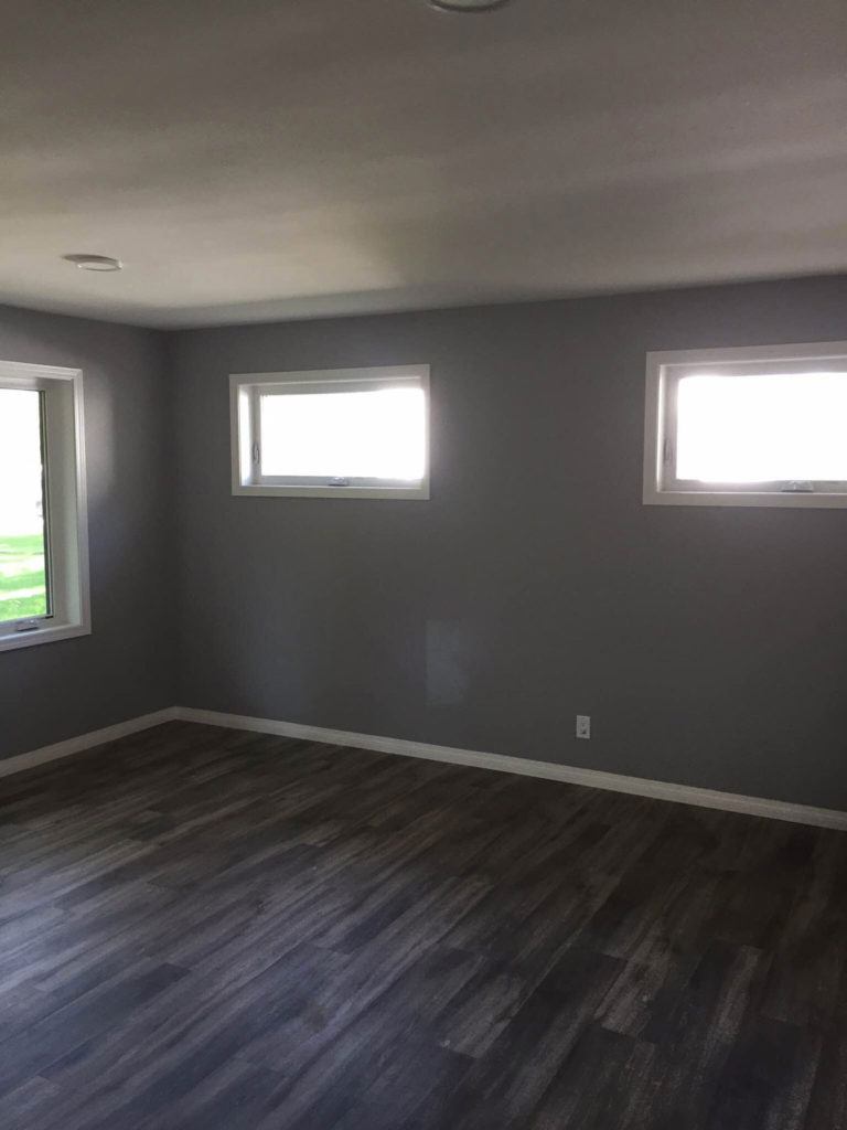 a newly renovated room with dark wood floors
