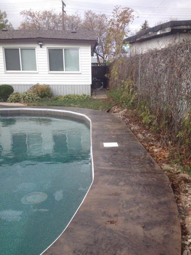 Stamped and coloured concrete surrounding in-ground pool