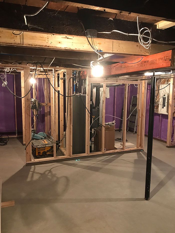 a basement renovation in progress with framed-in insulated walls and a new concrete floor