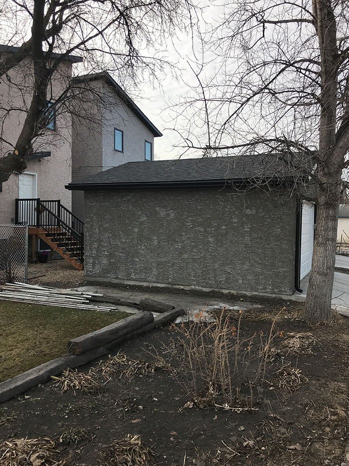 Newly built custom garage with a stone wall exterior